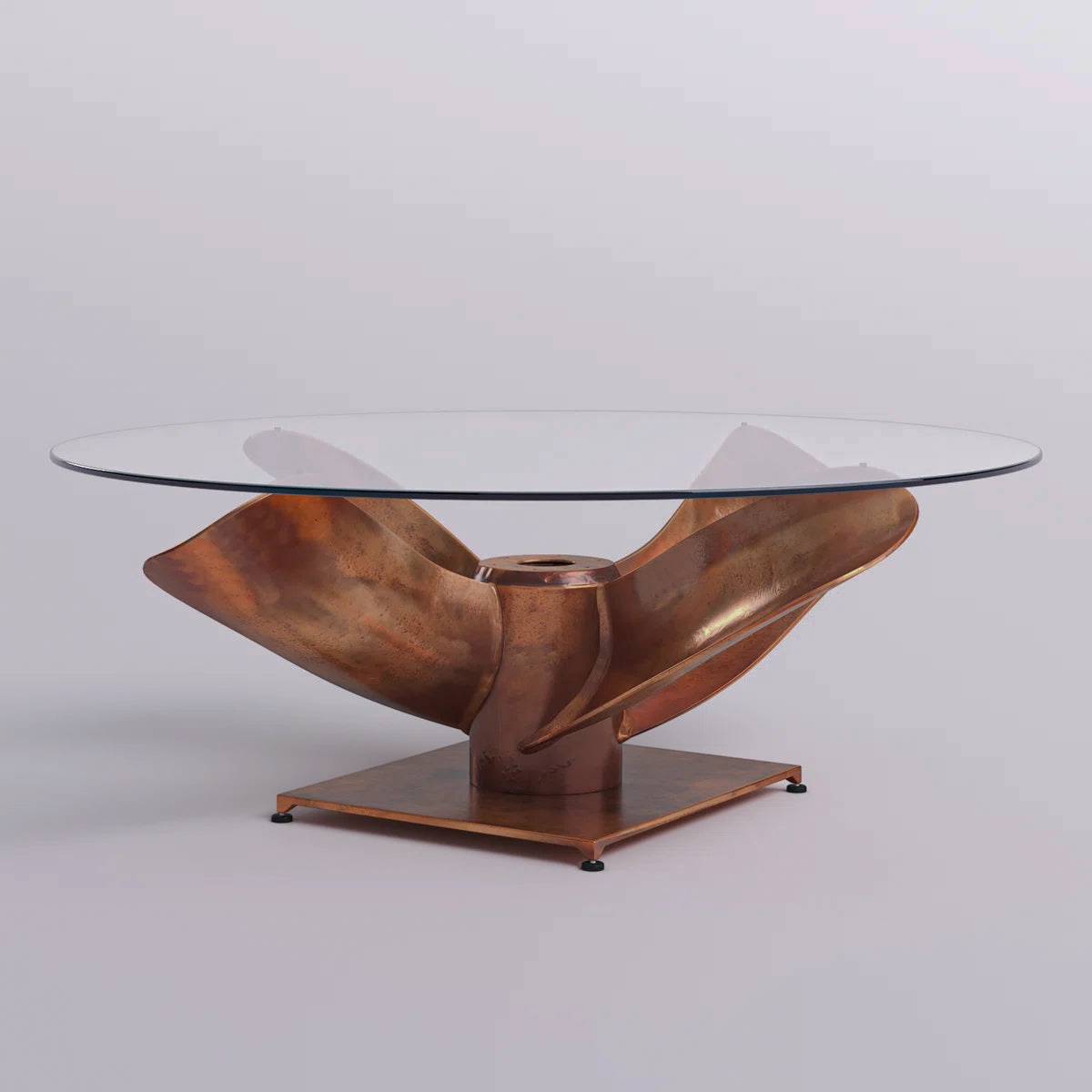Side view of the clear-top coffee table and sculptural copper-tone base