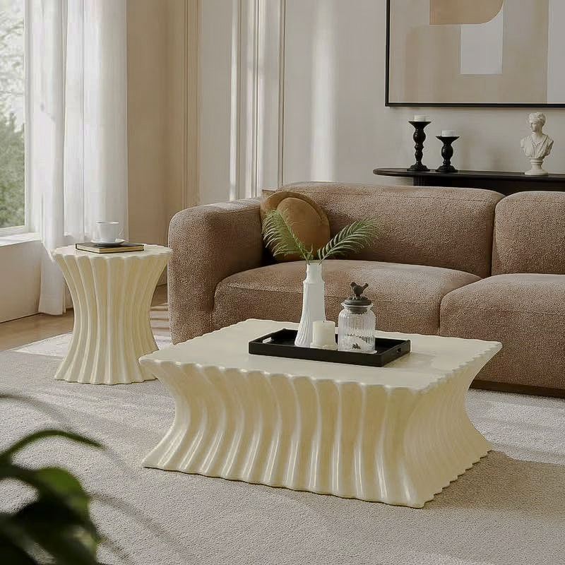 Cream fluted coffee table and matching hourglass-shaped side table beside a brown sofa