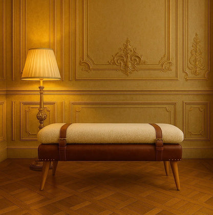 Cream and brown strap-detail bench with tapered legs in a warm paneled room