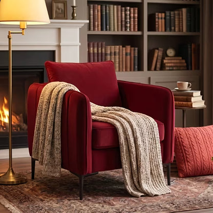 Burgundy armchair with a cream knitted throw beside a fireplace