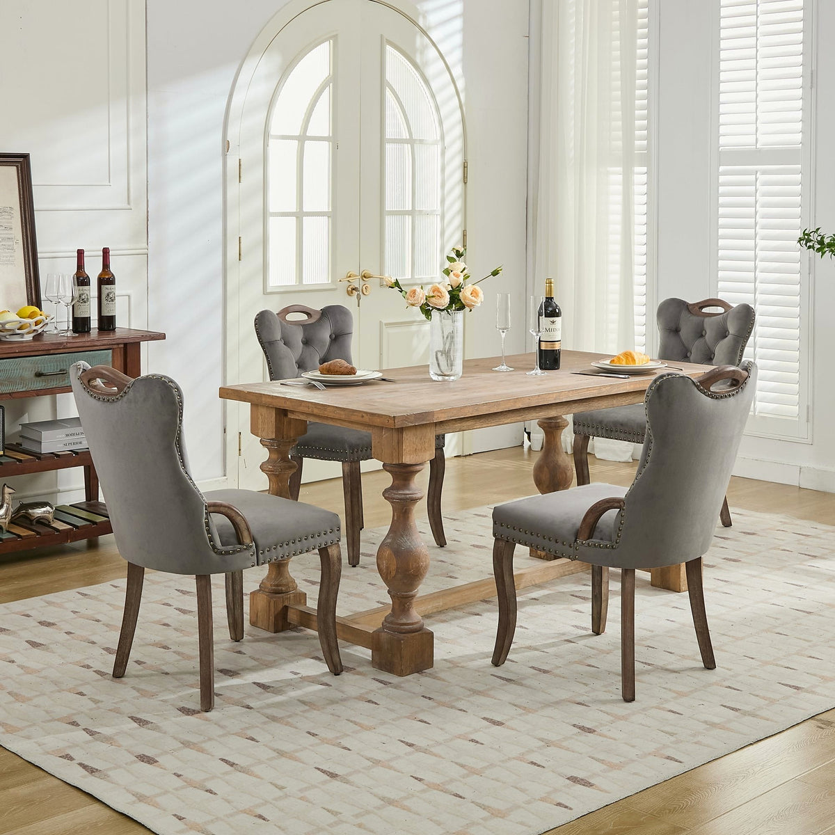 Gray velvet dining chair with a tufted back, wood handle, and curved wood legs
