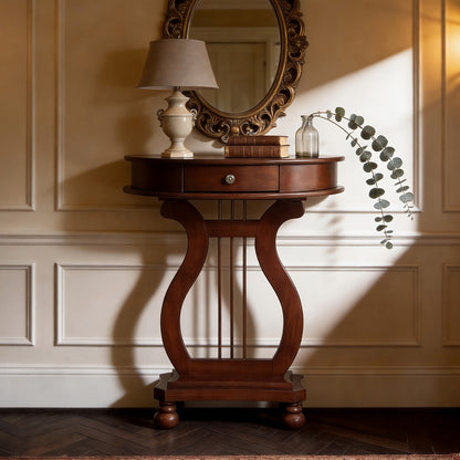 Cherry brown demi-lune console with a harp-shaped base below an ornate mirror.