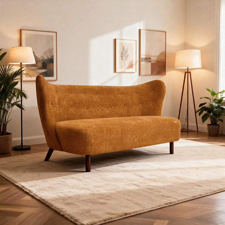 Caramel chenille loveseat shown at an angle in a softly lit room with floor lamps and a cream rug.