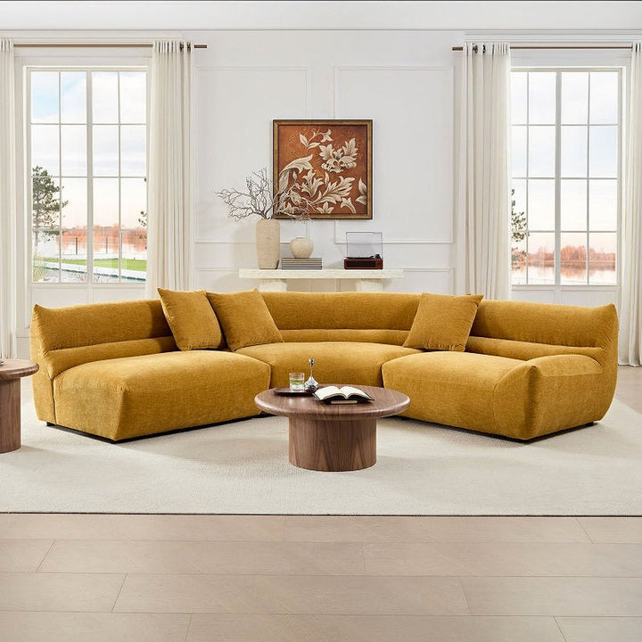 Yellow curved modular sectional arranged around a coffee table in a living room