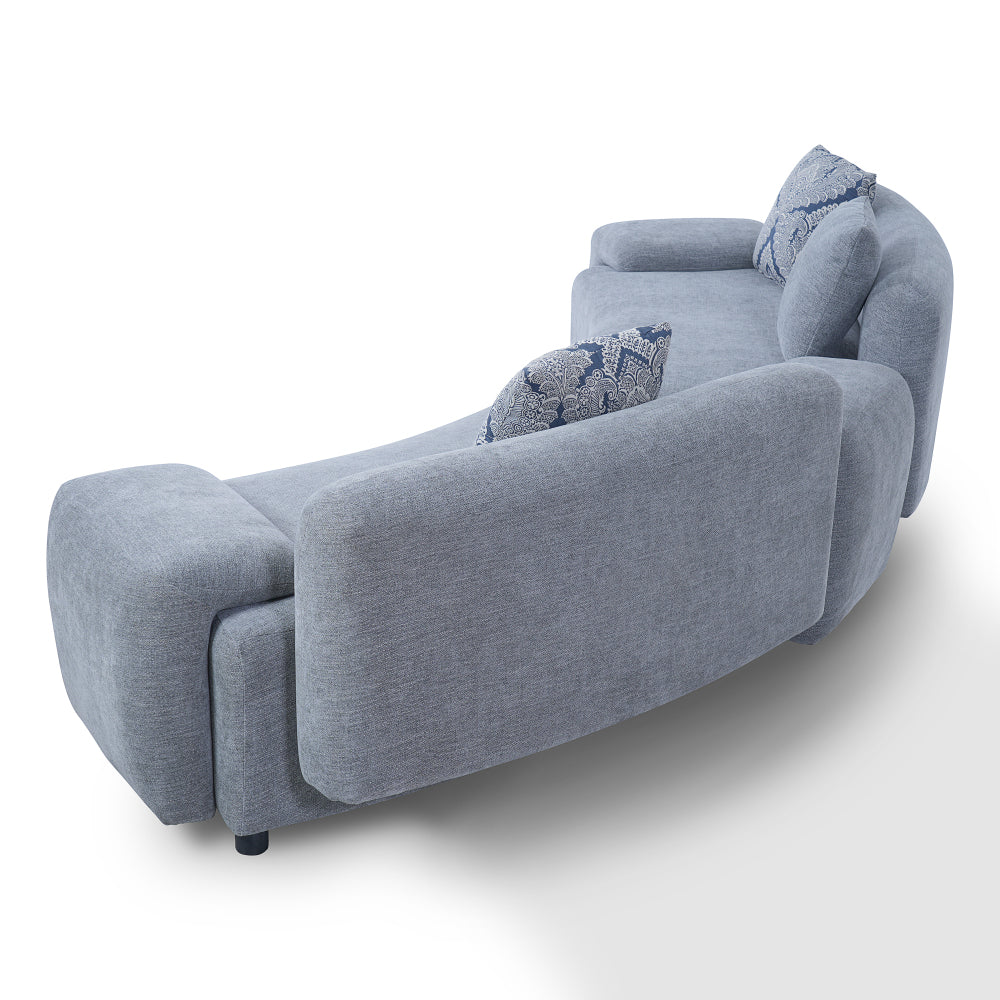 Blue-Grey Curved Sofa with Damask Pillows — rear three-quarter view.