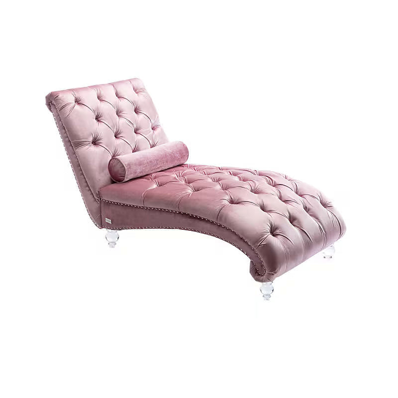 Pink velvet tufted chaise lounge with clear acrylic feet and a bolster pillow