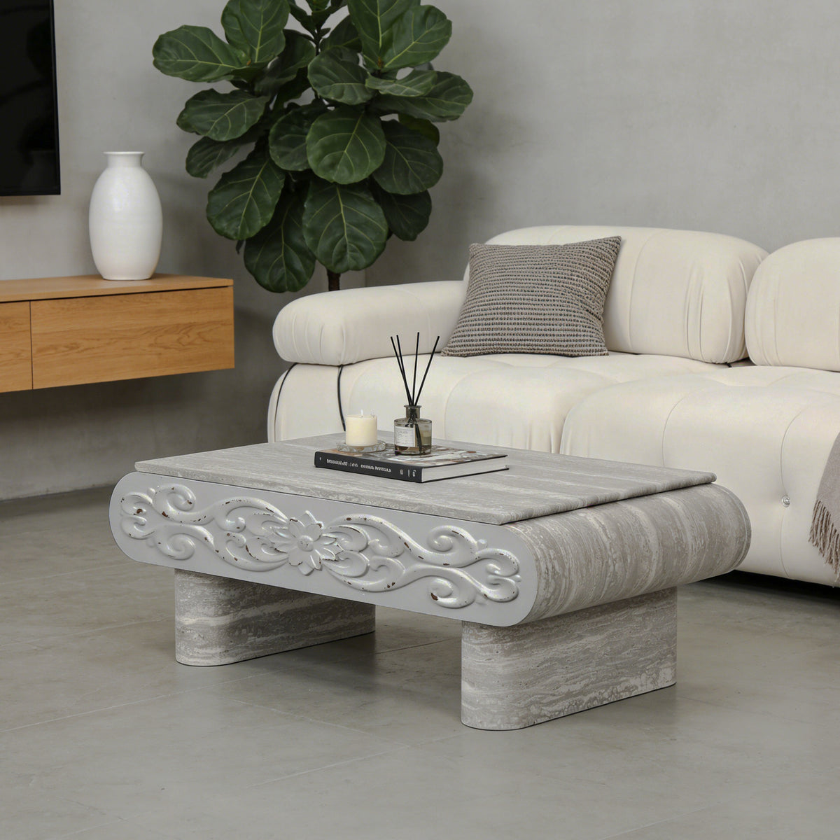 Angled room view of gray carved coffee table