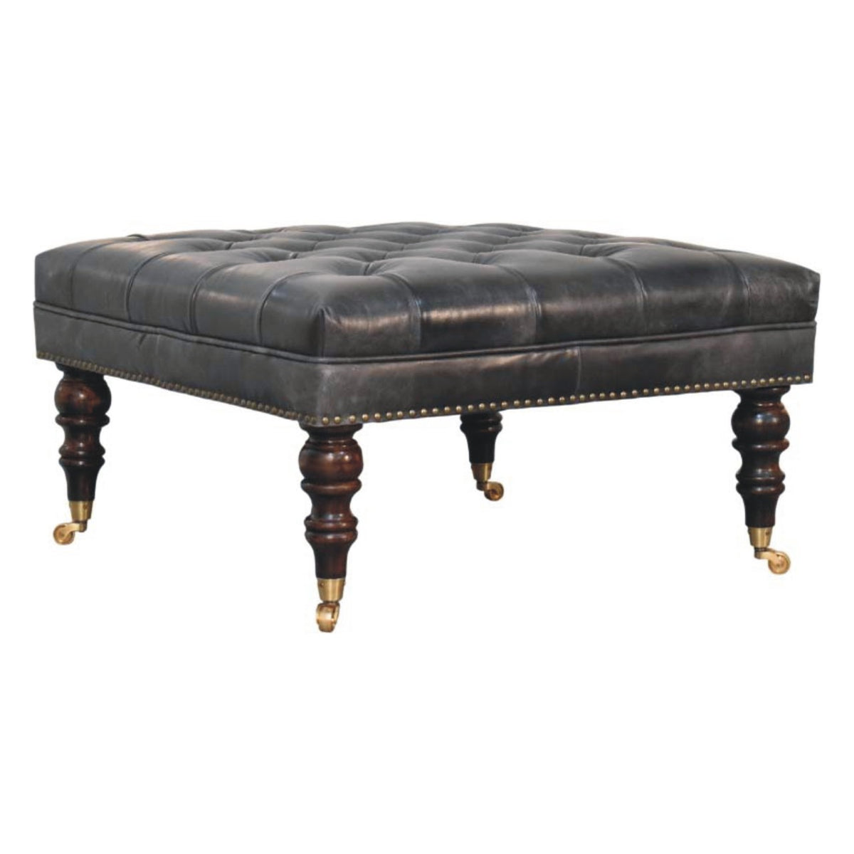 Angled view of the black ottoman's tufted cushion and turned legs