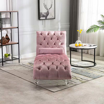 Pink velvet tufted chaise lounge with clear acrylic feet and a bolster pillow