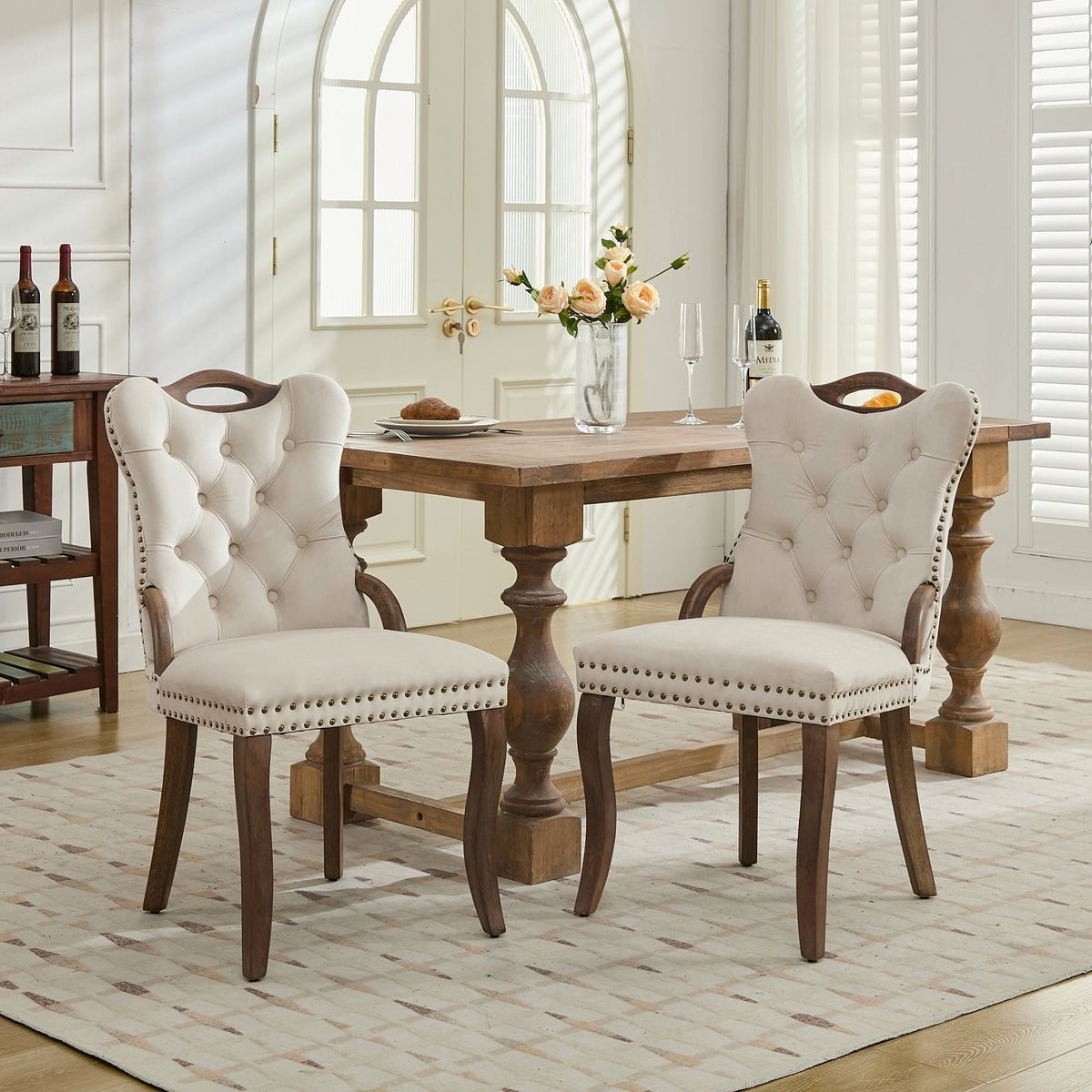 Beige velvet dining chair with a tufted back, wood handle, and curved wood legs