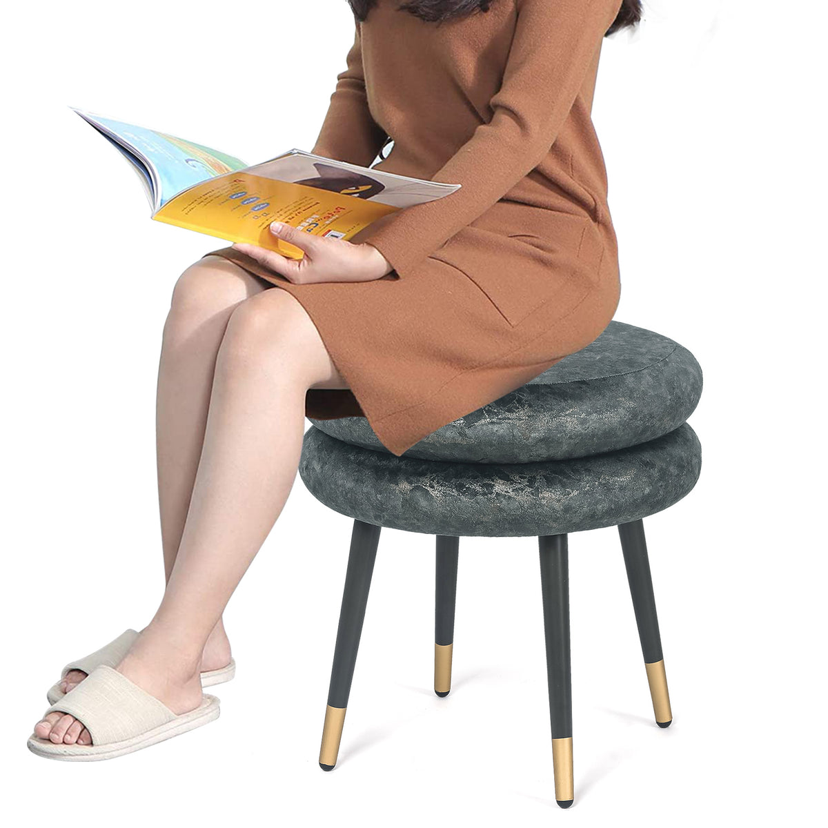 Person seated on the round double-cushion ottoman