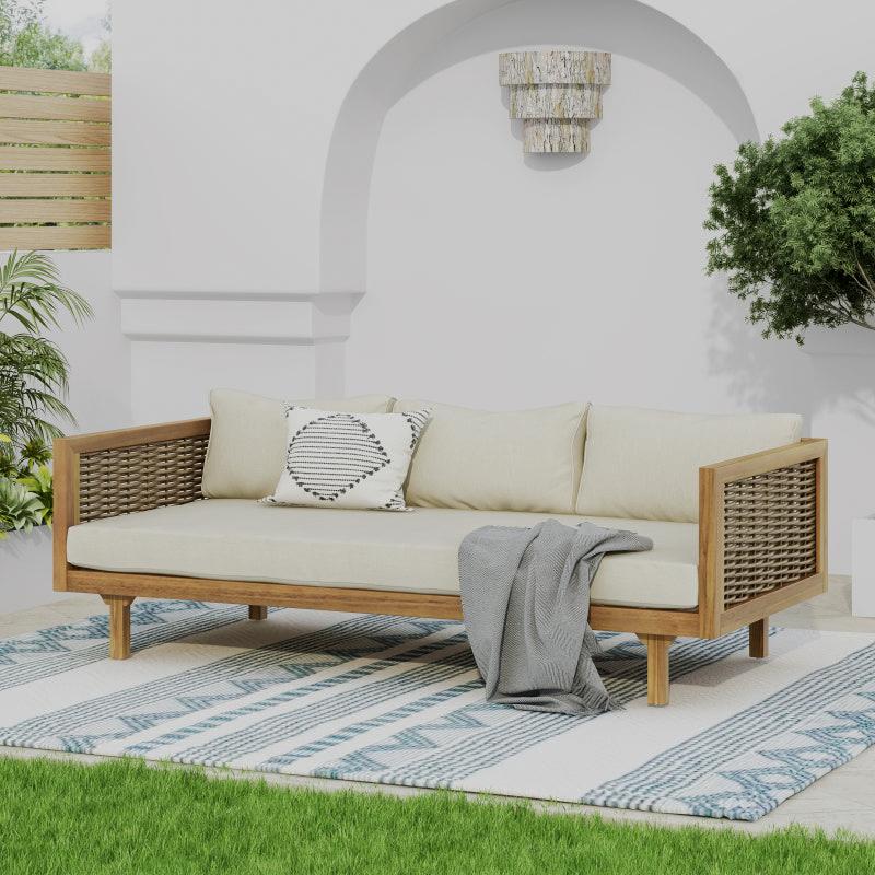 Patio sofa with beige cushions and woven side panels in a courtyard
