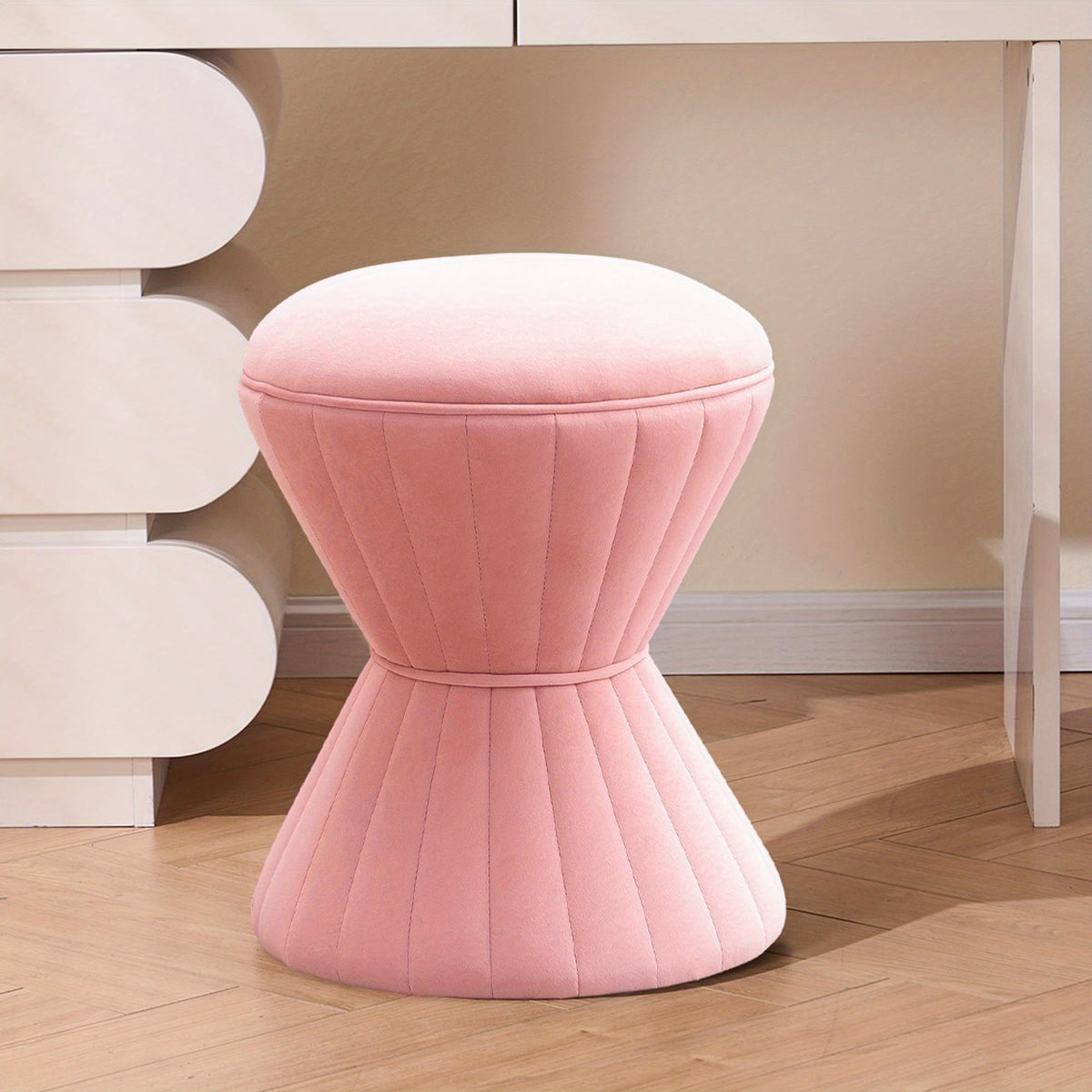 Pink velvet hourglass-shaped vanity stool
