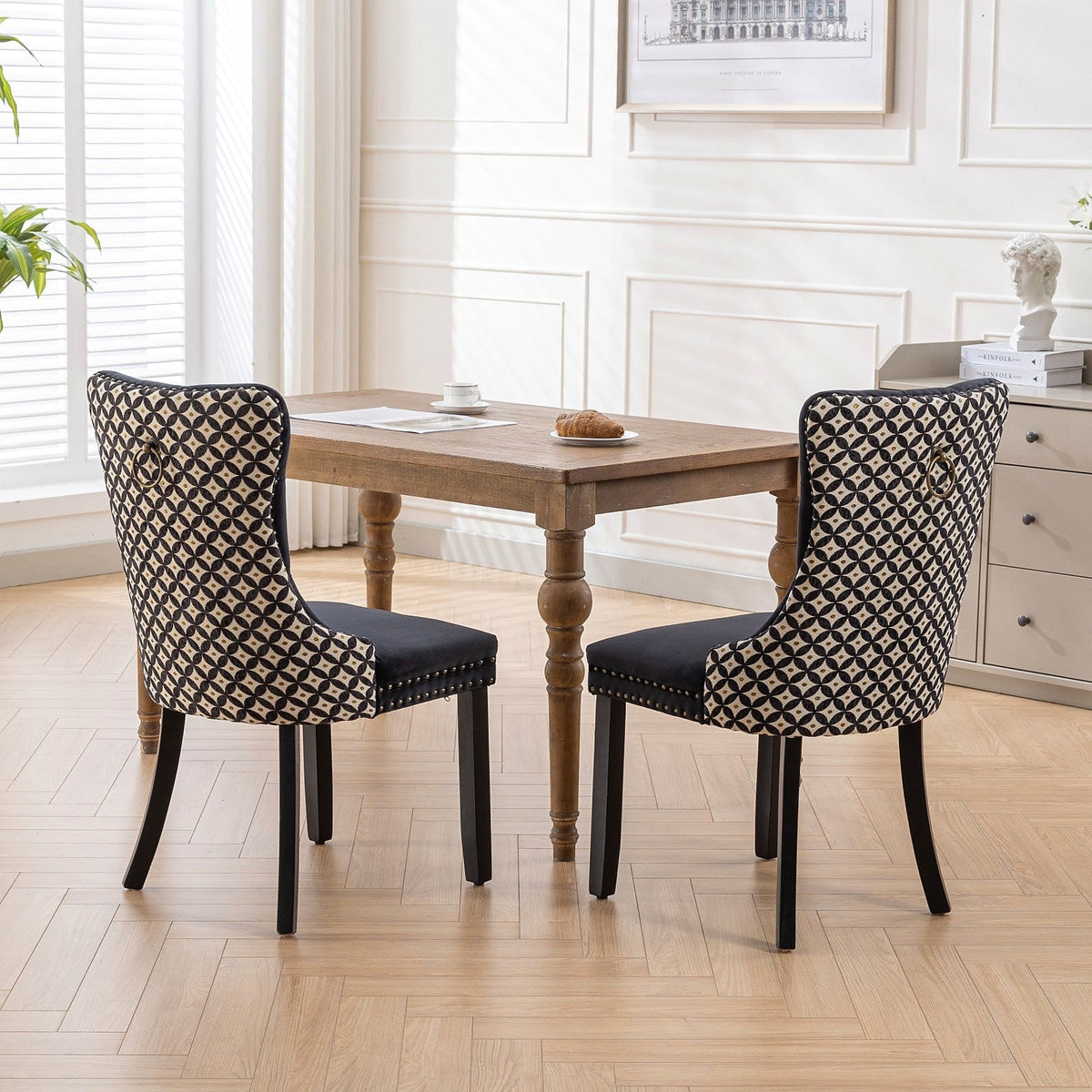 Black velvet dining chair with a patterned back and dark wood legs