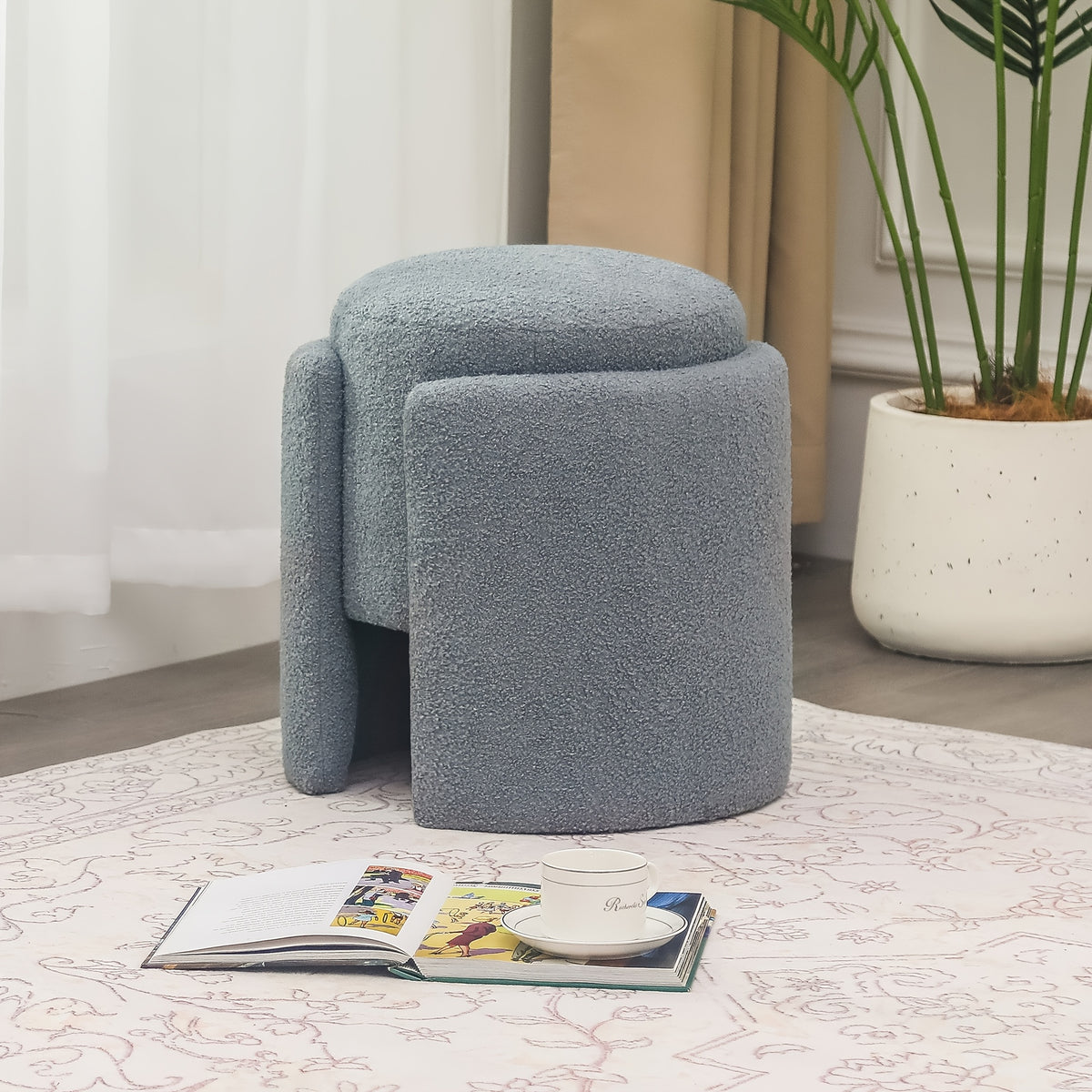 Grey sculptural upholstered ottoman in a bedroom setting
