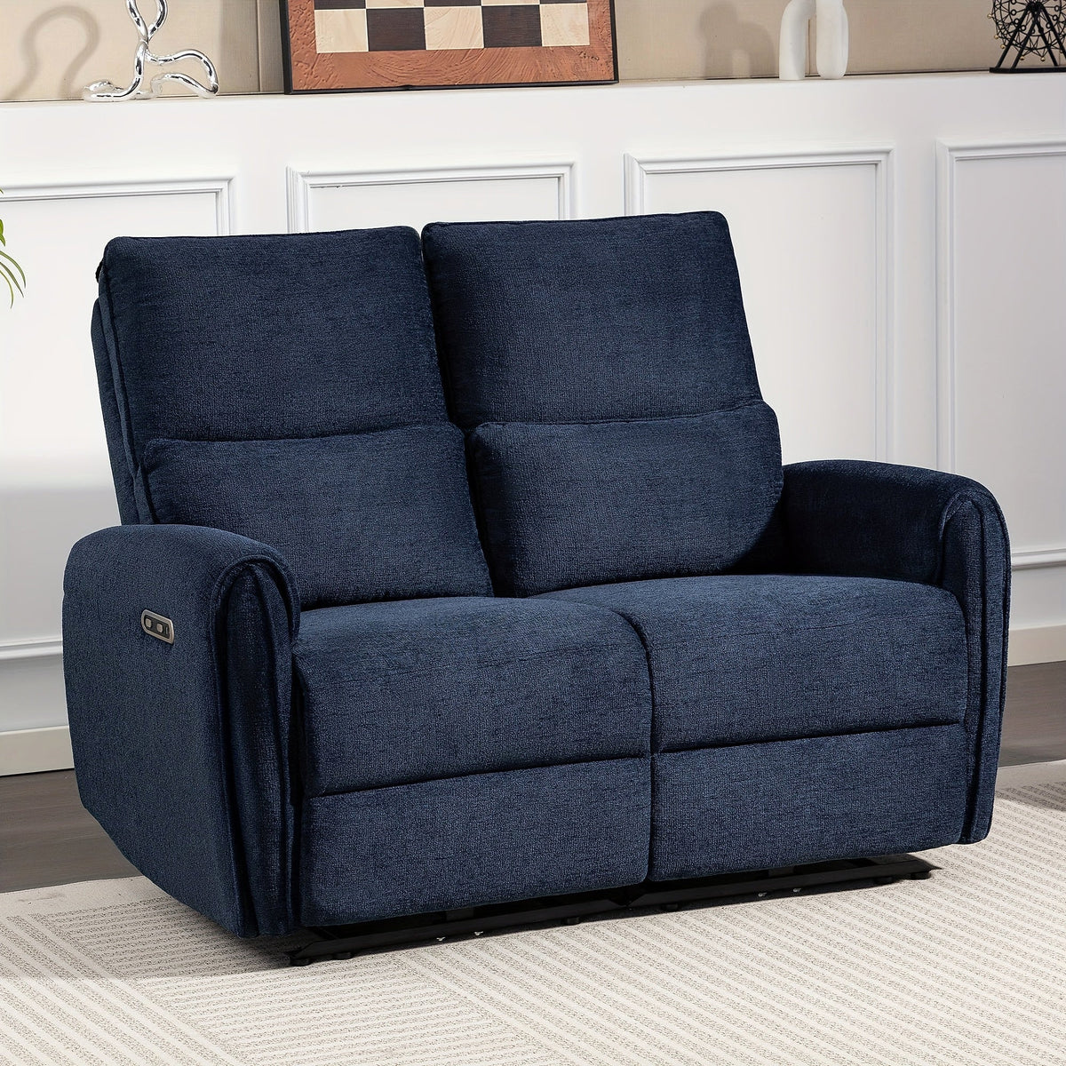 Blue two-seat power reclining loveseat with padded arms and lumbar cushions in a living room.