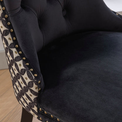 Black velvet dining chair with a patterned back and dark wood legs