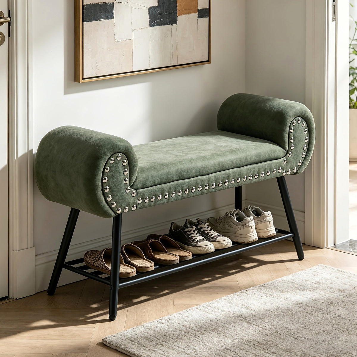Green rolled arm upholstered shoe bench with a black metal rack and silver tone nailheads