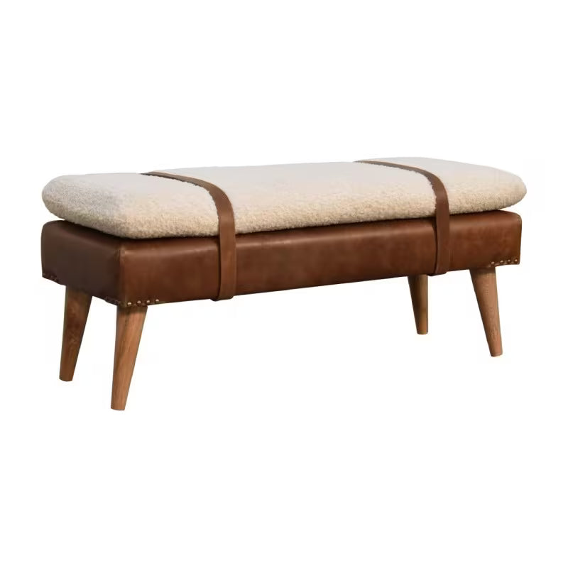 Isolated angled view of cream boucle-style bench with brown straps and tapered legs