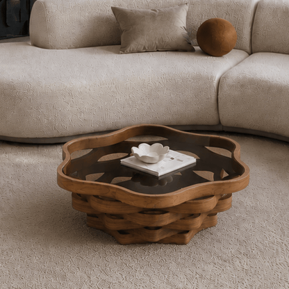 Cloud-shaped glass-top coffee table with layered brown base in a living room