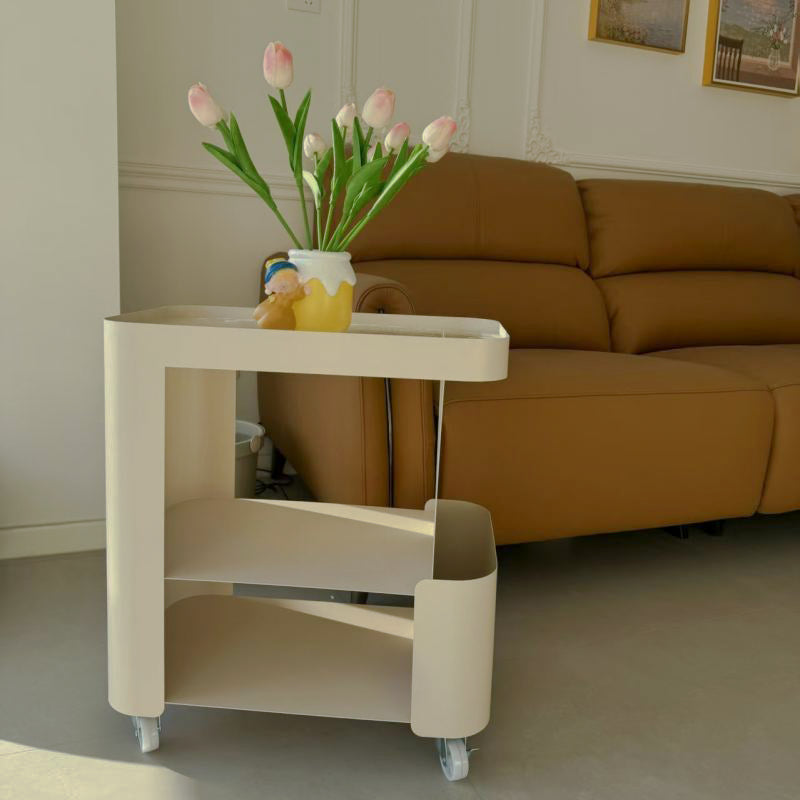 Angled view of rounded cream metal side table and side pocket