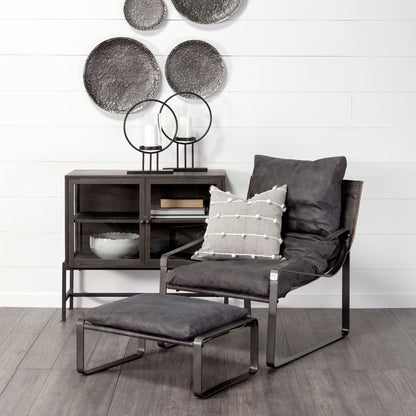 Black leather accent chair in a styled room; ottoman, cushion and accessories shown for styling and are not included.