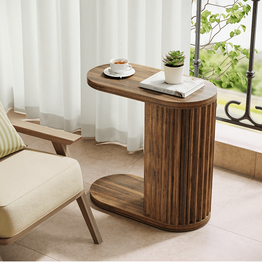 Fluted oval side table beside a chair near a window.