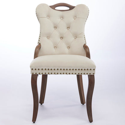 Beige velvet dining chair with a tufted back, wood handle, and curved wood legs