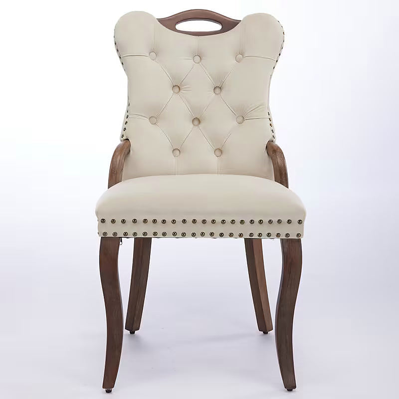 Beige velvet dining chair with a tufted back, wood handle, and curved wood legs