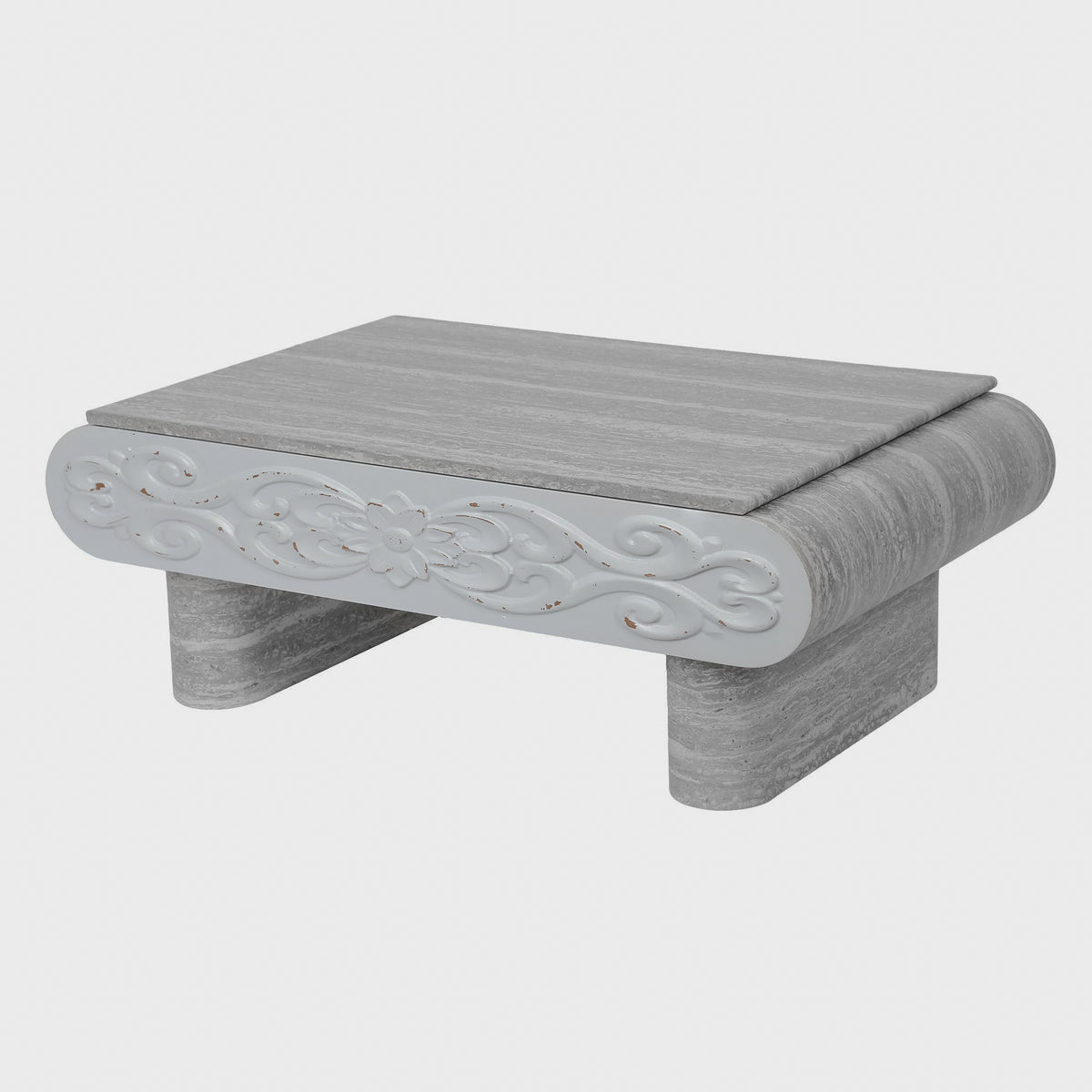 Three-quarter view of gray coffee table with carved front