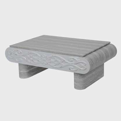 Three-quarter view of gray coffee table with carved front