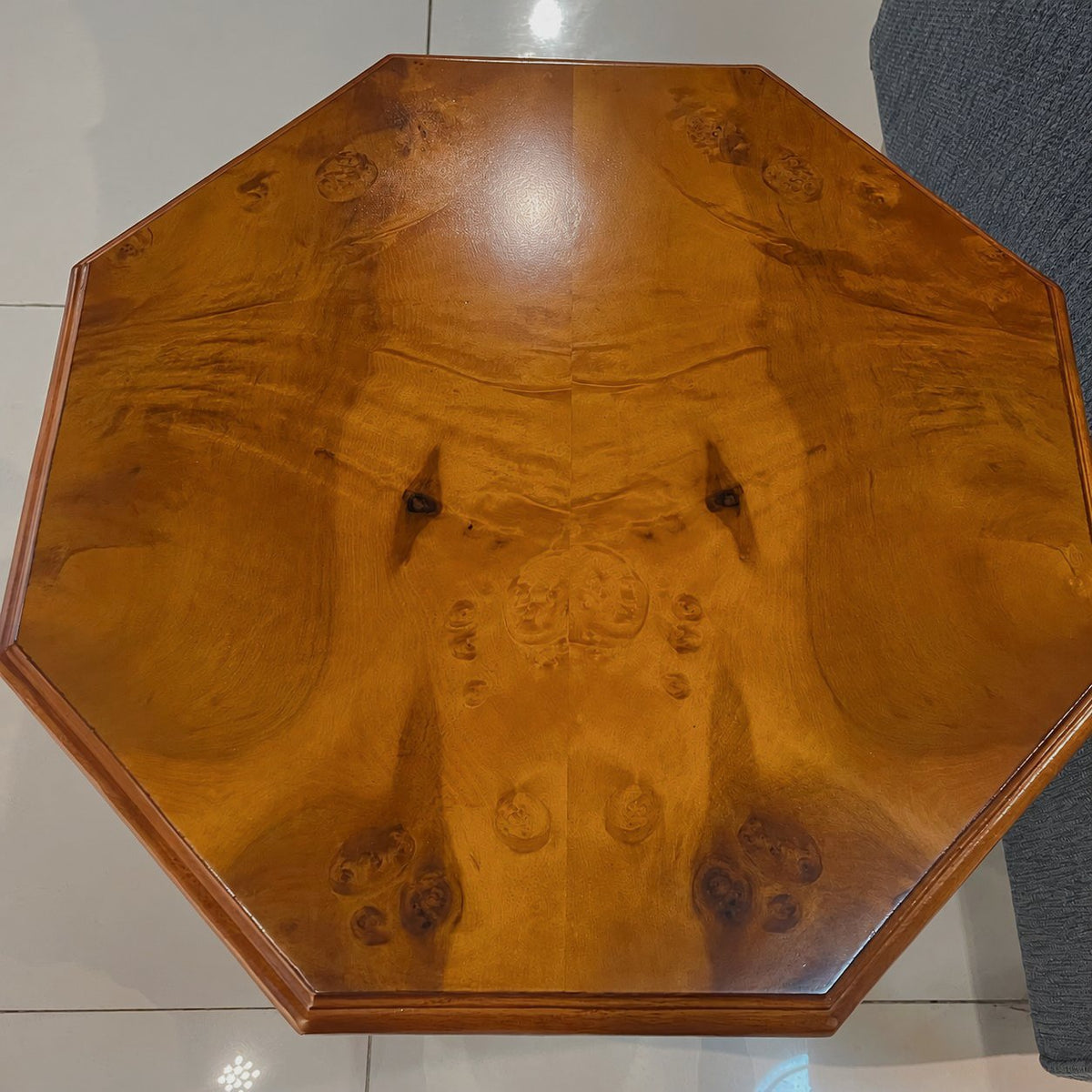 Octagonal burl wood side table — close overhead view of walnut-finish tabletop and molded edge