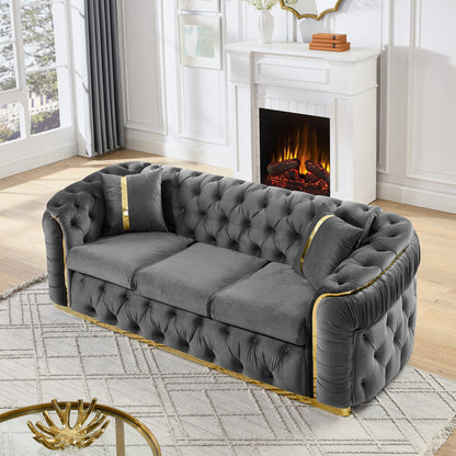Velvet Chesterfield Sofa with Gold-Tone Trim — grey sofa three-quarter view.