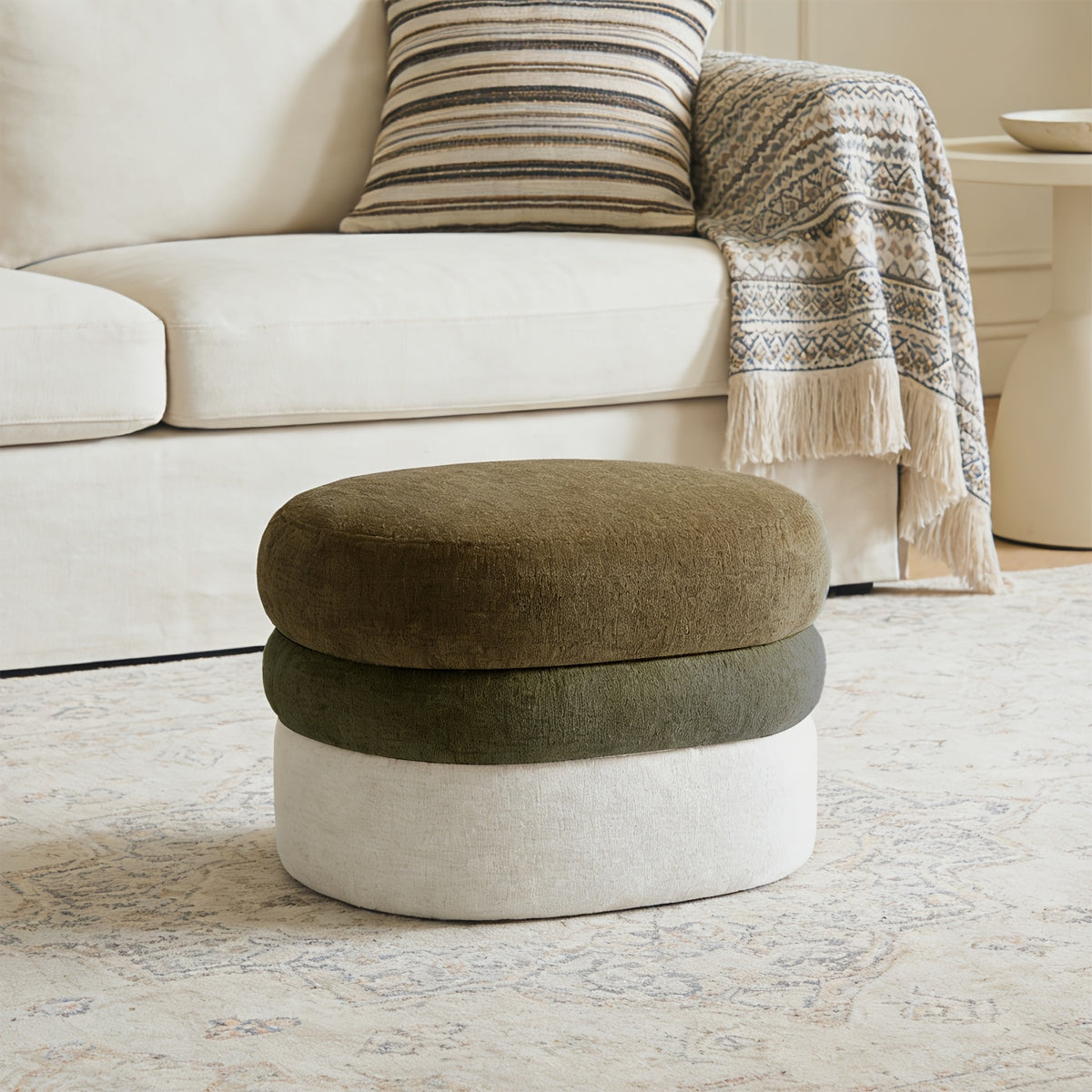 Olive-and-cream ombre ottoman beside sofa