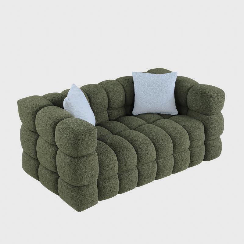 Angled studio view of the olive green block-tufted sofa