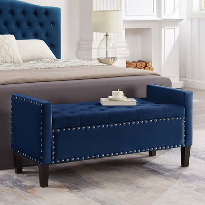 Navy tufted storage bench at the foot of a bed