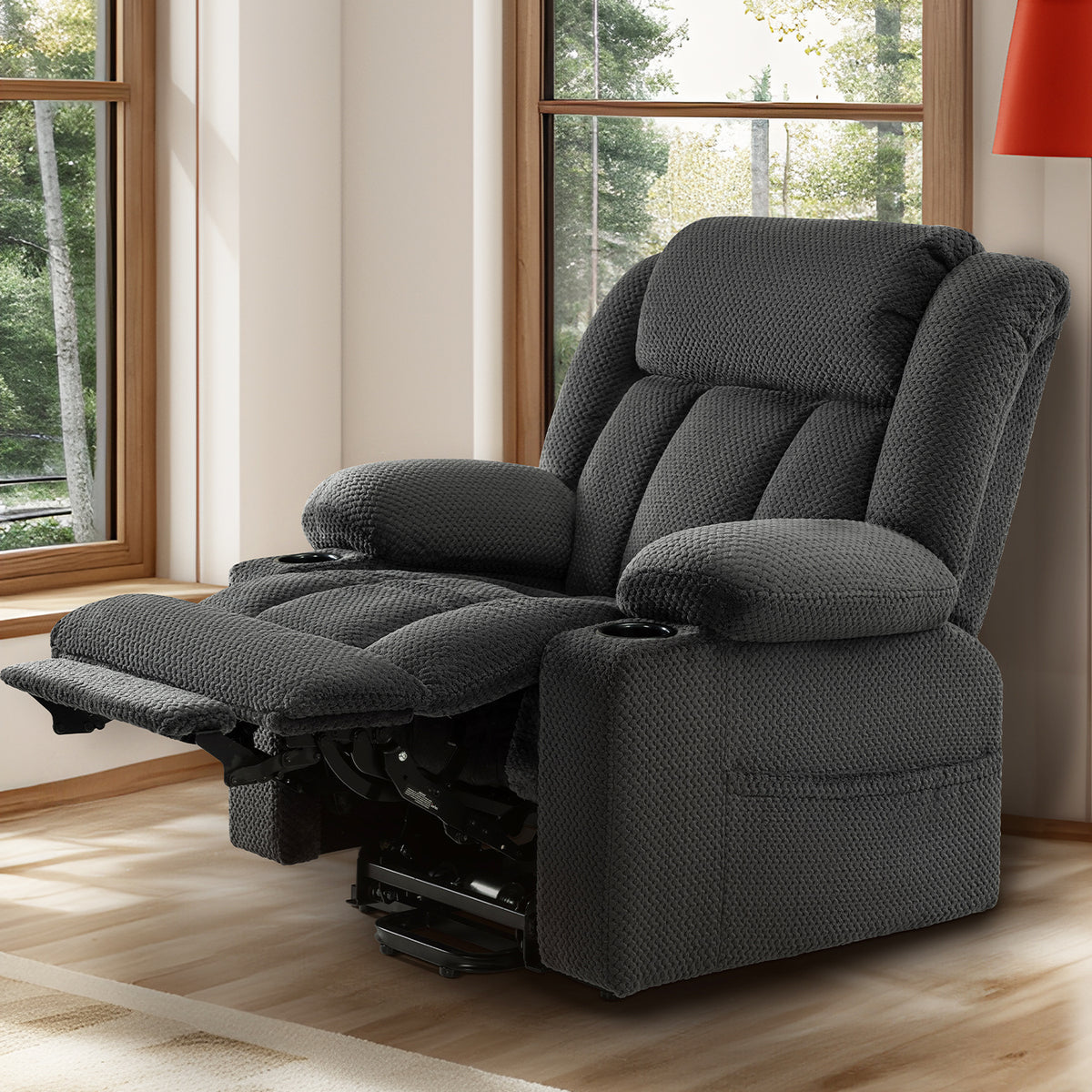 Gray padded recliner showing the extended footrest and dark mechanism below