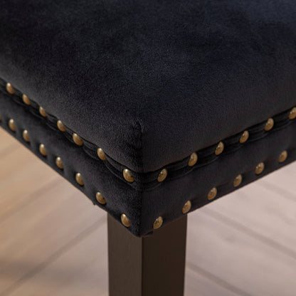 Black velvet dining chair with a patterned back and dark wood legs