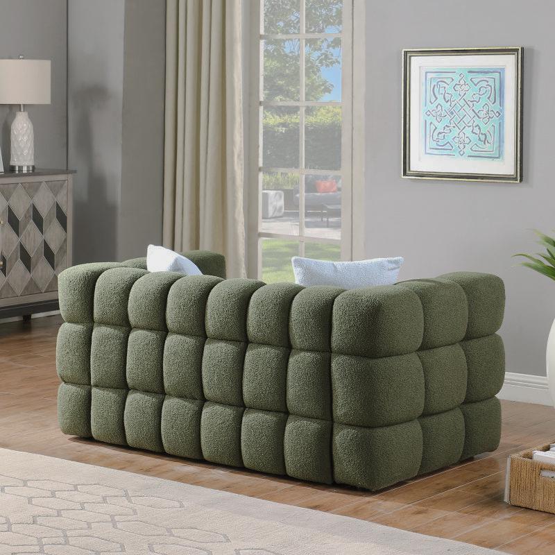 Angled view of the olive green sofa's rounded block-tufted sides