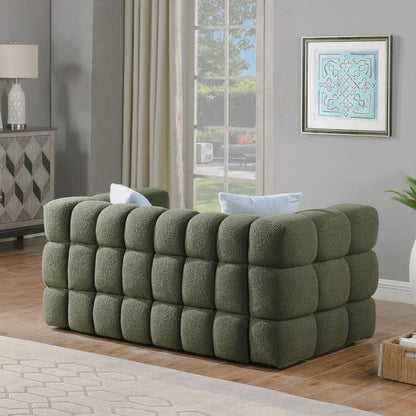 Angled view of the olive green sofa's rounded block-tufted sides