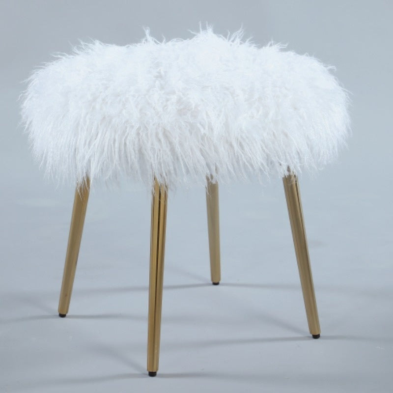 Angled view of white furry stool and gold-tone legs