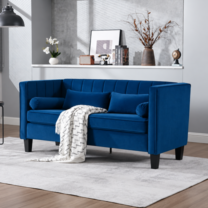 Cohaven Velvet Loveseat with Bolster Pillows — blue velvet loveseat in a living room.