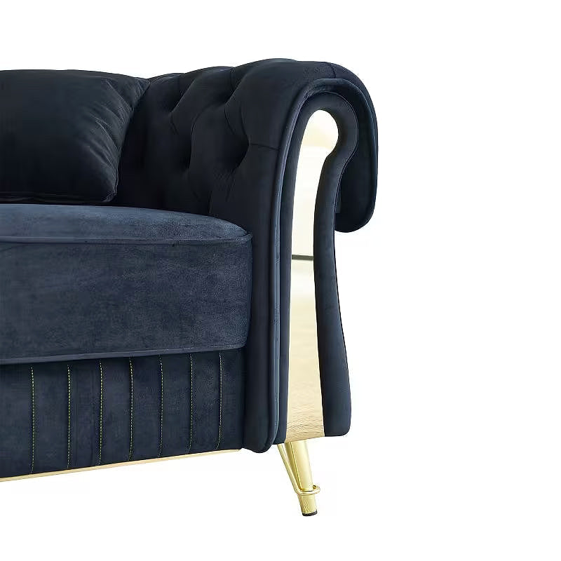 Detail of the black velvet sofa arm trim and tapered gold-tone foot