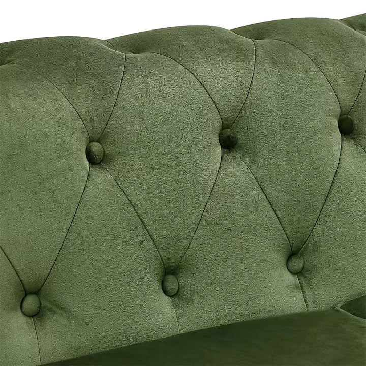 Close-up of diamond button tufting on the green velvet loveseat