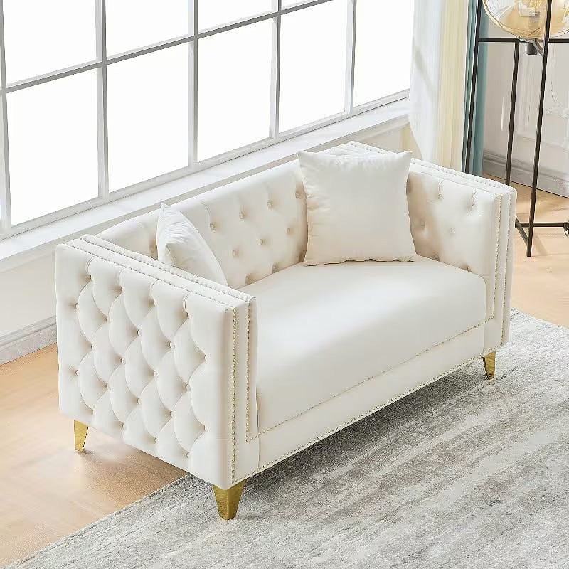 Beige Chesterfield loveseat, elevated angled view showing tufted arms
