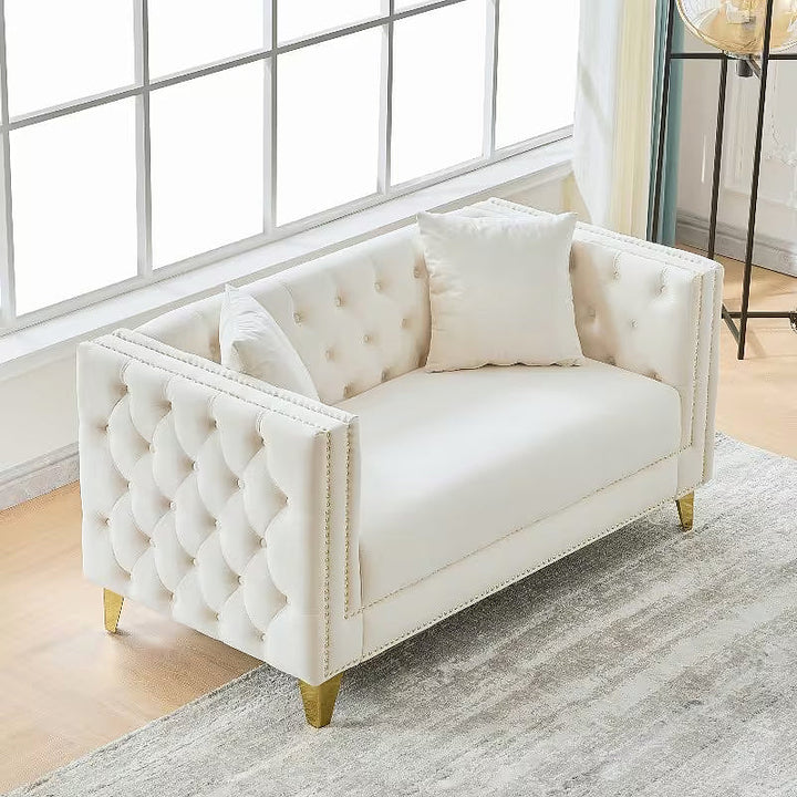 Beige Chesterfield loveseat, elevated angled view showing tufted arms