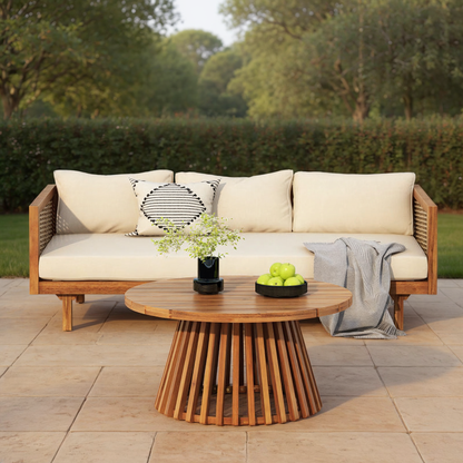 Patio sofa with beige cushions and a round slatted-base table on a garden terrace