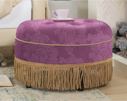 Purple fringed ottoman styled with a teacup beside a sofa