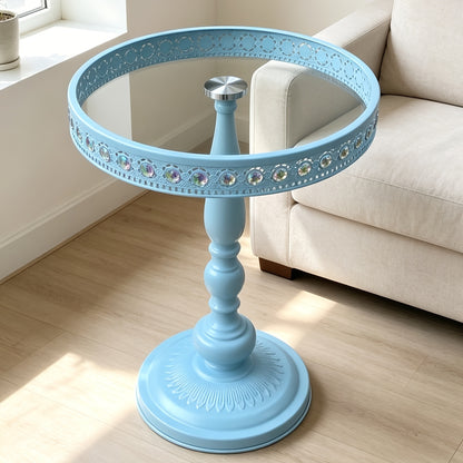 Light blue pedestal table showing its glass top and decorative rim.