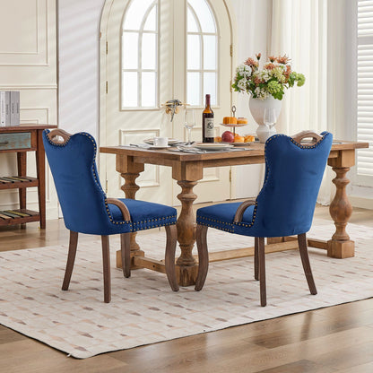 Blue velvet dining chair with a tufted back, wood handle, and curved wood legs